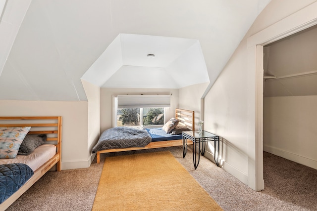 bedroom with lofted ceiling, carpet, and baseboards