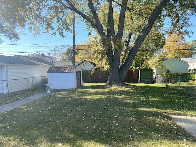 view of yard featuring an outbuilding, a fenced backyard, and a shed