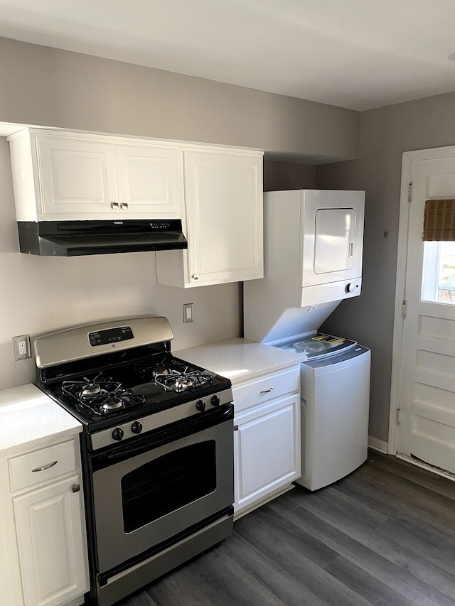 kitchen with gas stove, white cabinetry, under cabinet range hood, and stacked washer / dryer