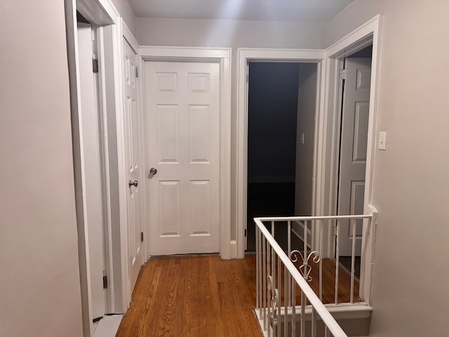 hallway featuring wood finished floors and an upstairs landing