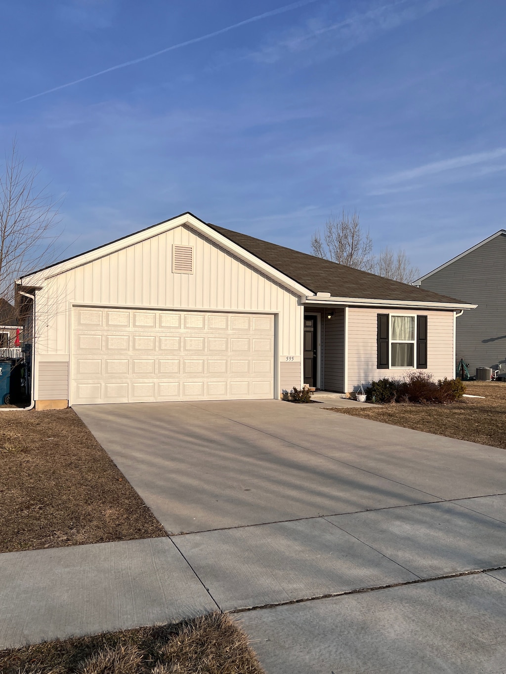 single story home featuring a garage, board and batten siding, and concrete driveway