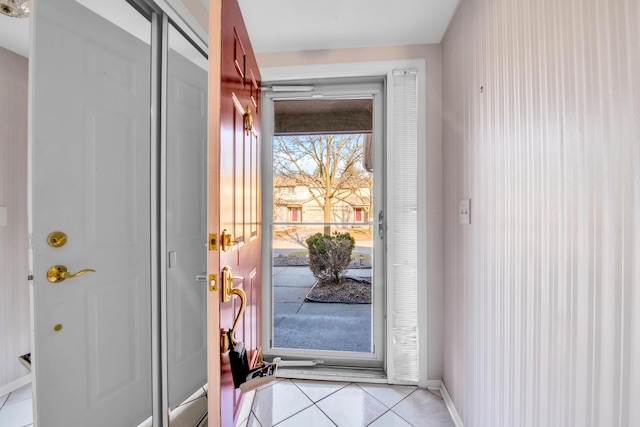 doorway to outside with light tile patterned floors and baseboards