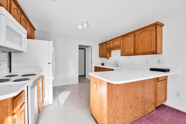 kitchen with white appliances, brown cabinetry, a peninsula, a sink, and light countertops