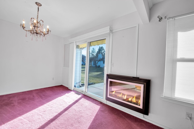 spare room with a notable chandelier, visible vents, baseboards, and carpet