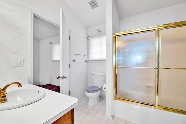 bathroom with vanity, visible vents, tile patterned floors, toilet, and combined bath / shower with glass door