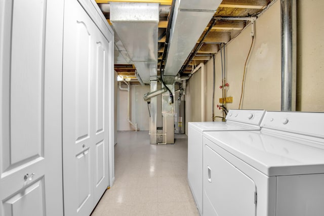 washroom with laundry area, gas water heater, light floors, and washing machine and clothes dryer