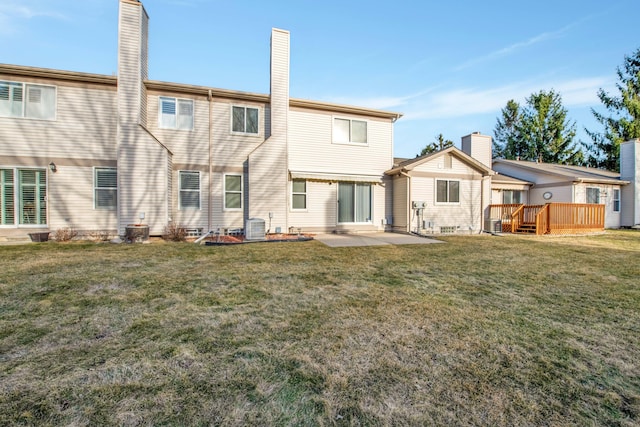 rear view of property featuring a yard, cooling unit, a wooden deck, and a chimney