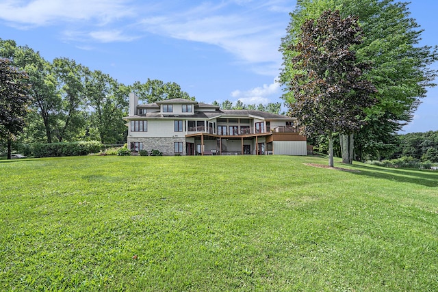 back of house with a deck, a yard, and a chimney