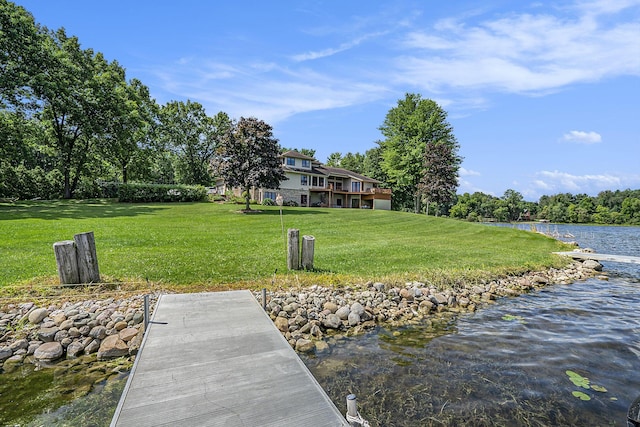 view of dock featuring a deck with water view and a lawn