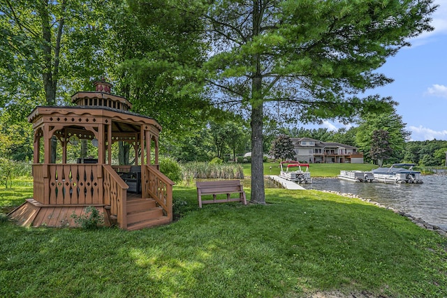 view of yard with a gazebo, a water view, and a dock