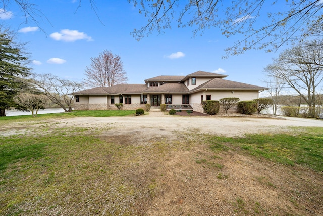 view of front of property featuring a front lawn and a water view