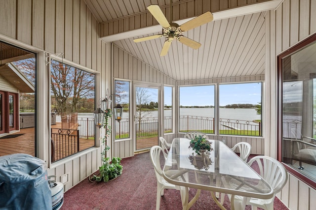 sunroom with a water view, ceiling fan, and vaulted ceiling with beams