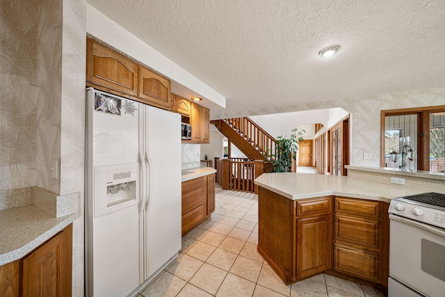 kitchen with brown cabinets, plenty of natural light, white appliances, light tile patterned flooring, and light countertops