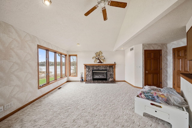 living room with a high end fireplace, baseboards, ceiling fan, lofted ceiling, and carpet floors