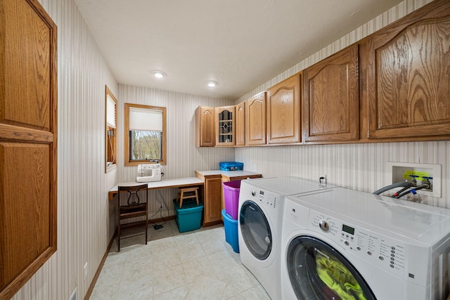 laundry area with wallpapered walls, baseboards, washer and clothes dryer, light tile patterned floors, and cabinet space