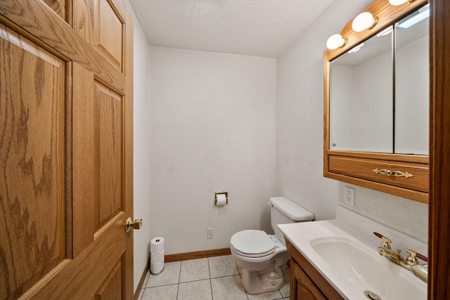 bathroom with tile patterned floors, toilet, a textured ceiling, baseboards, and vanity