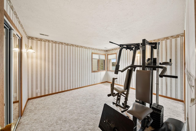 workout area featuring baseboards, carpet floors, a textured ceiling, and wallpapered walls