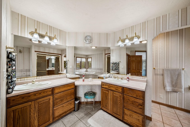 bathroom with a sink, tile patterned floors, and wallpapered walls