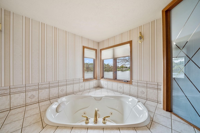 bathroom featuring a jetted tub, wallpapered walls, and a textured ceiling