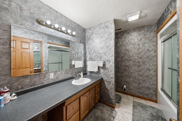 bathroom featuring baseboards, a textured ceiling, vanity, and wallpapered walls