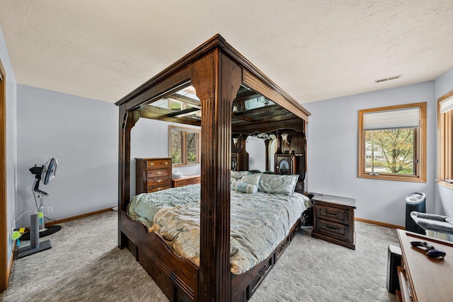 bedroom with visible vents, baseboards, a textured ceiling, and carpet flooring