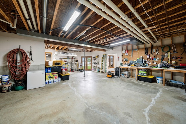 basement with a workshop area and white refrigerator