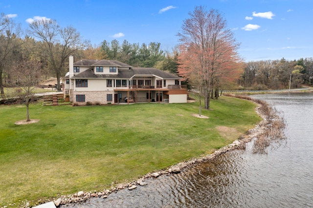 exterior space with a chimney, a deck with water view, and a front yard