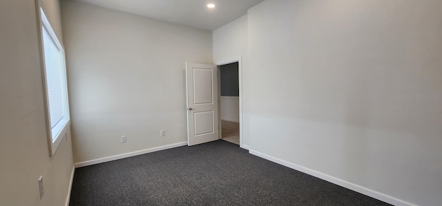 unfurnished room with recessed lighting, dark carpet, and baseboards