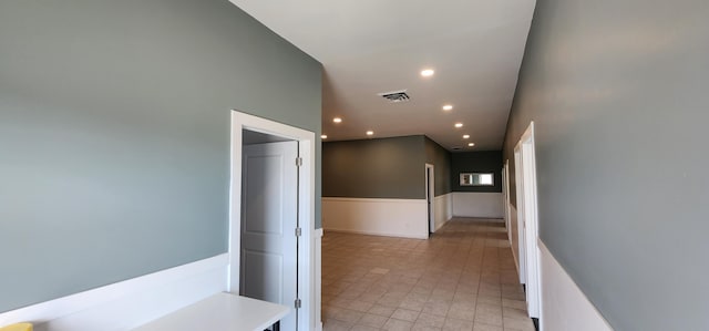 hall featuring recessed lighting, visible vents, and wainscoting