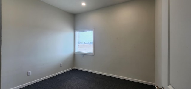 spare room with recessed lighting and baseboards