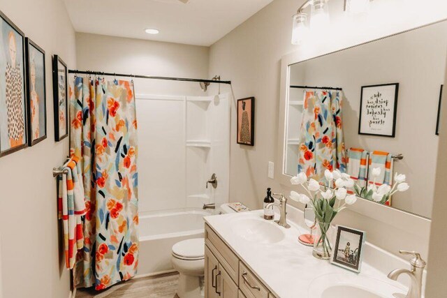 5227 Brinson Ln, Kalamazoo, MI 49009 - full bathroom featuring double vanity, toilet, shower / bath combo, and a sink