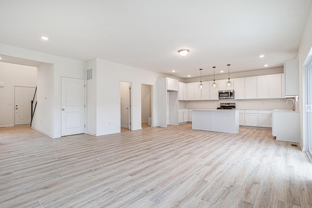 5227 Brinson Ln, Kalamazoo, MI 49009 - unfurnished living room with light wood-style flooring and recessed lighting