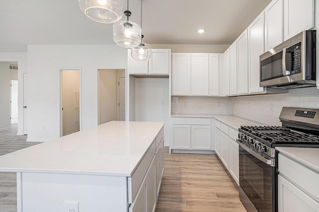 5227 Brinson Ln, Kalamazoo, MI 49009 - kitchen with stainless steel appliances, a center island, light wood-type flooring, decorative backsplash, and recessed lighting