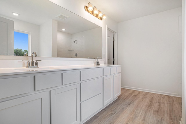 5227 Brinson Ln, Kalamazoo, MI 49009 - full bath featuring double vanity, wood finished floors, a tile shower, and recessed lighting