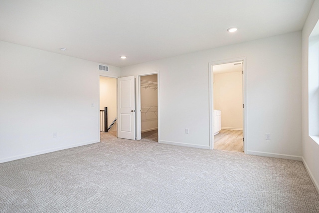 5227 Brinson Ln, Kalamazoo, MI 49009 - unfurnished bedroom featuring light carpet, a walk in closet, recessed lighting, a closet, and ensuite bath
