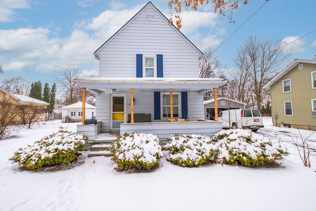 snow covered property with covered porch