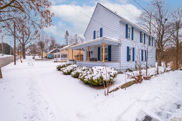 view of snow covered exterior featuring covered porch