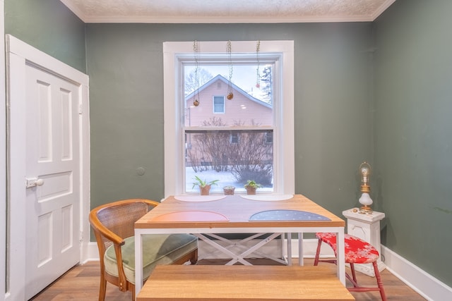 dining room with baseboards, wood finished floors, and ornamental molding