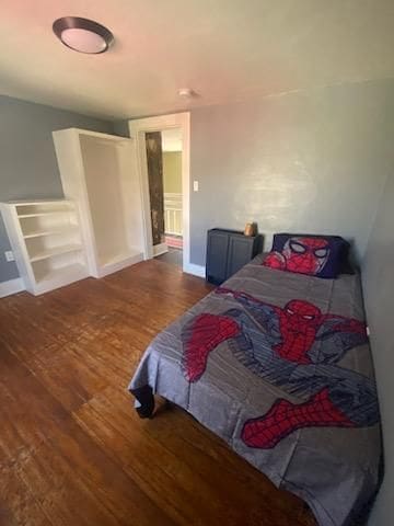 bedroom featuring baseboards and wood finished floors