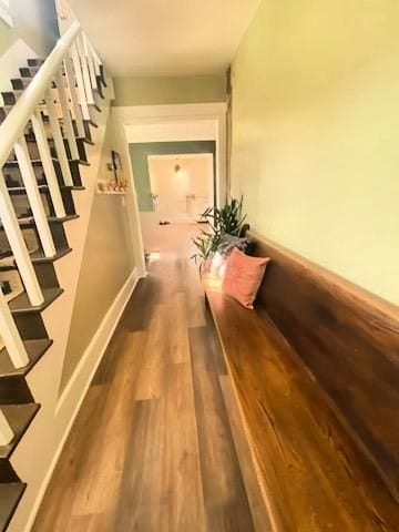 corridor featuring stairway, baseboards, and wood finished floors