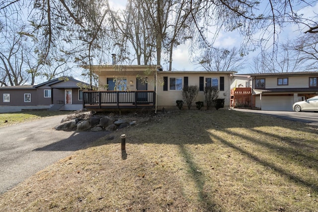 ranch-style house featuring driveway, a front yard, and a deck