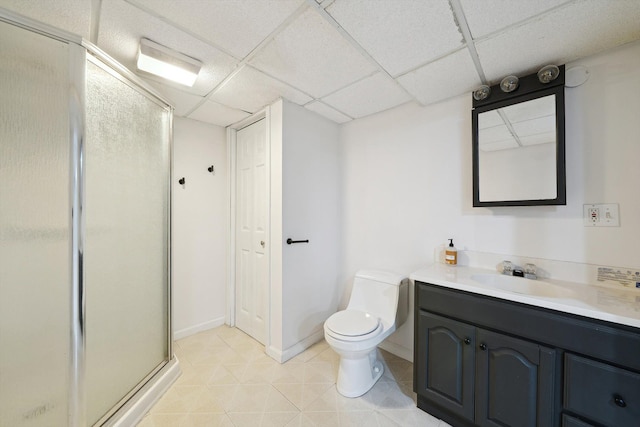 full bath with vanity, a shower stall, a paneled ceiling, tile patterned floors, and toilet