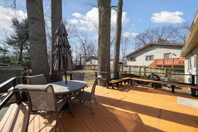 wooden terrace with outdoor dining area and fence