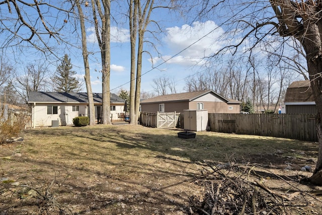 view of yard with an outbuilding, a shed, cooling unit, and fence