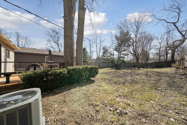 view of yard featuring fence and central AC