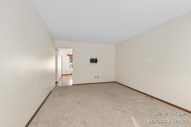 spare room with visible vents, baseboards, and carpet