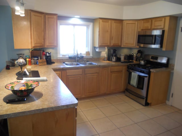 kitchen featuring light tile patterned floors, stainless steel appliances, light countertops, and a sink