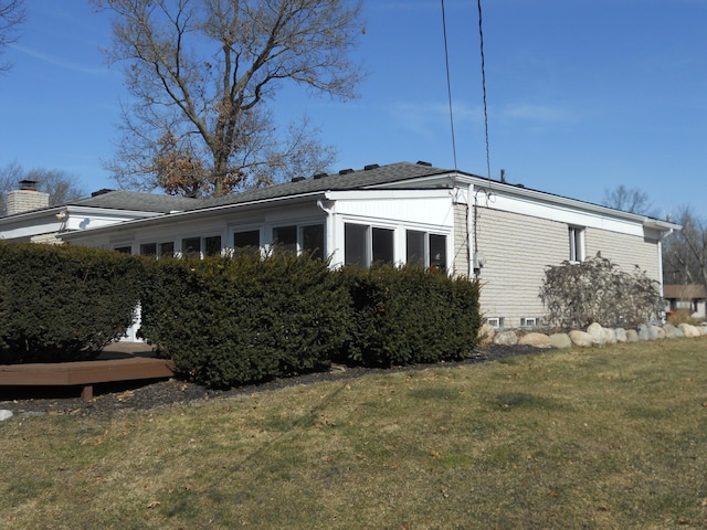 view of side of home with a yard and a sunroom