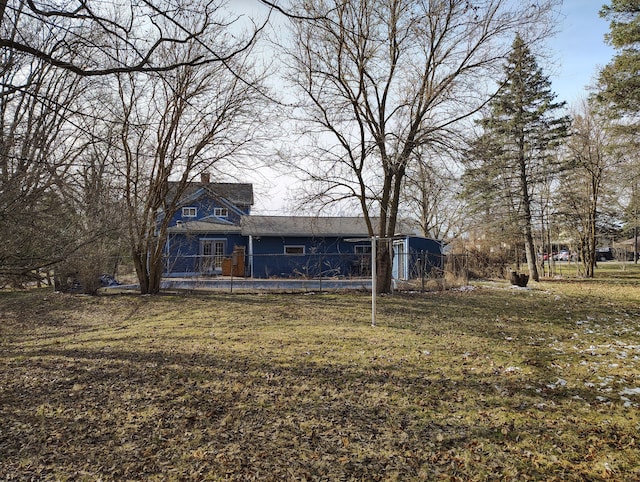 rear view of house with a chimney and a yard