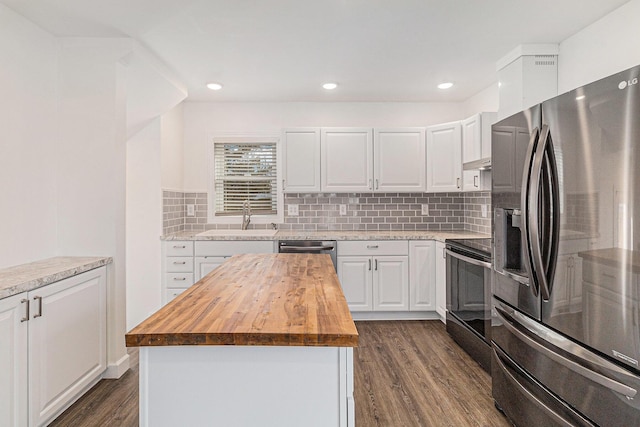 kitchen featuring wooden counters, a sink, stainless steel appliances, dark wood-type flooring, and white cabinetry